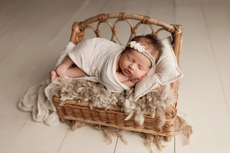 Newborn Photographer, a baby lays sleeping in a tiny boho style basinet, a perfect fit